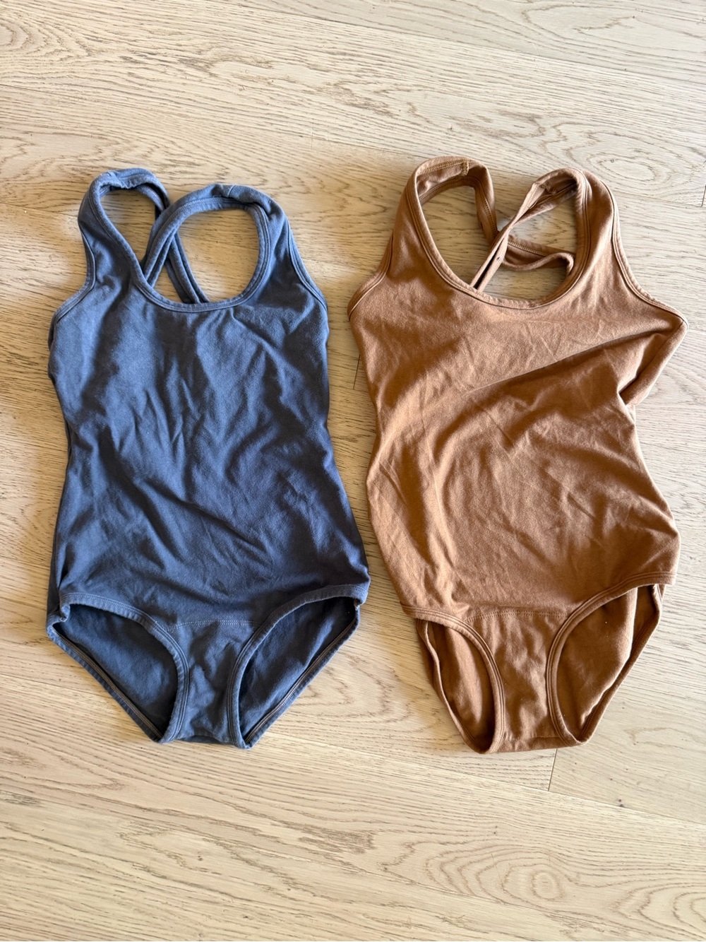 ARQ Crossback One-Piece Bodysuits in Blue and Brown